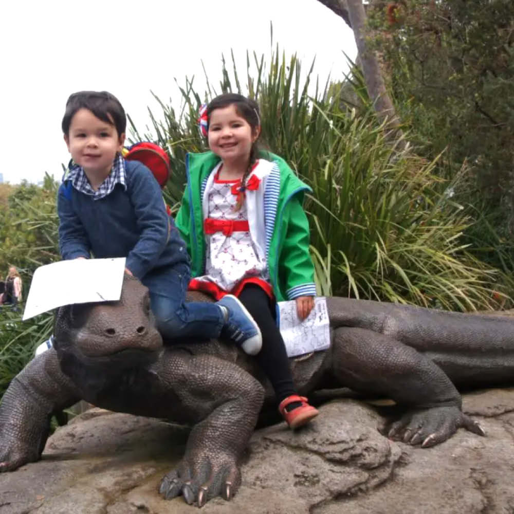 Natureworks Australia Komodo Dragon sculpture - front view- 080121 - shown with 2 children posing sitting on top
