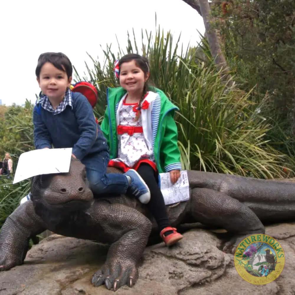 Natureworks Australia Komodo Dragon sculpture - front view- 080121 - shown with 2 children posing sitting on top
