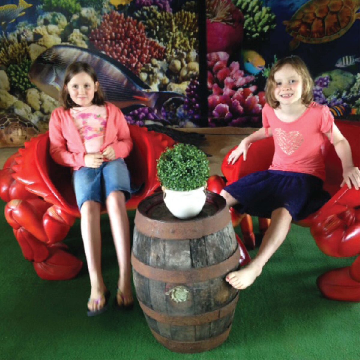 Natureworks Australia Crab Chair - 090079Red -shown in exhibit at Forster boat shed with two girls sitting in chairs