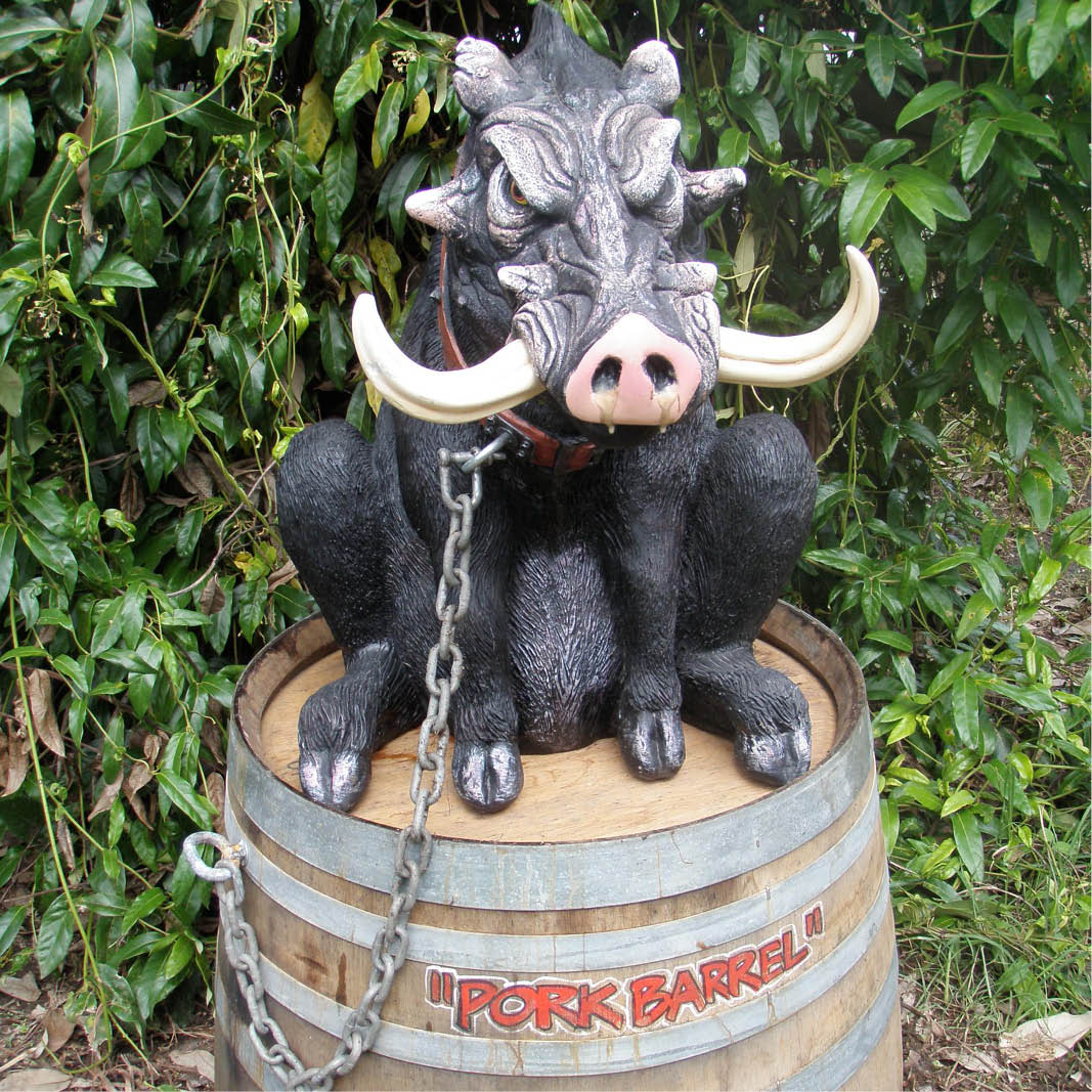 Natureworks Australia Fugly the guard hog on barrel with chain- showing small barren or planter turned upside down.