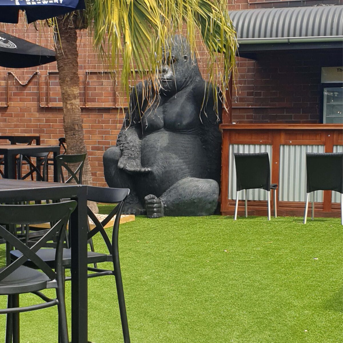 Natureworks Australia Giant Gorilla - Silverback in sitting posse - 8ft high black statue - 110088- shown in commercial setting