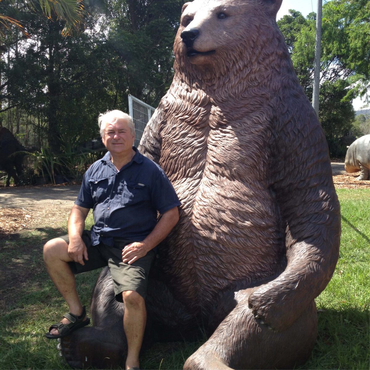 Natureworks Australia Grizzly Bear - Sitting - Jumbo size 130011- Shown with owner of Natureworks - David Joffe outside sitting on the bears hand