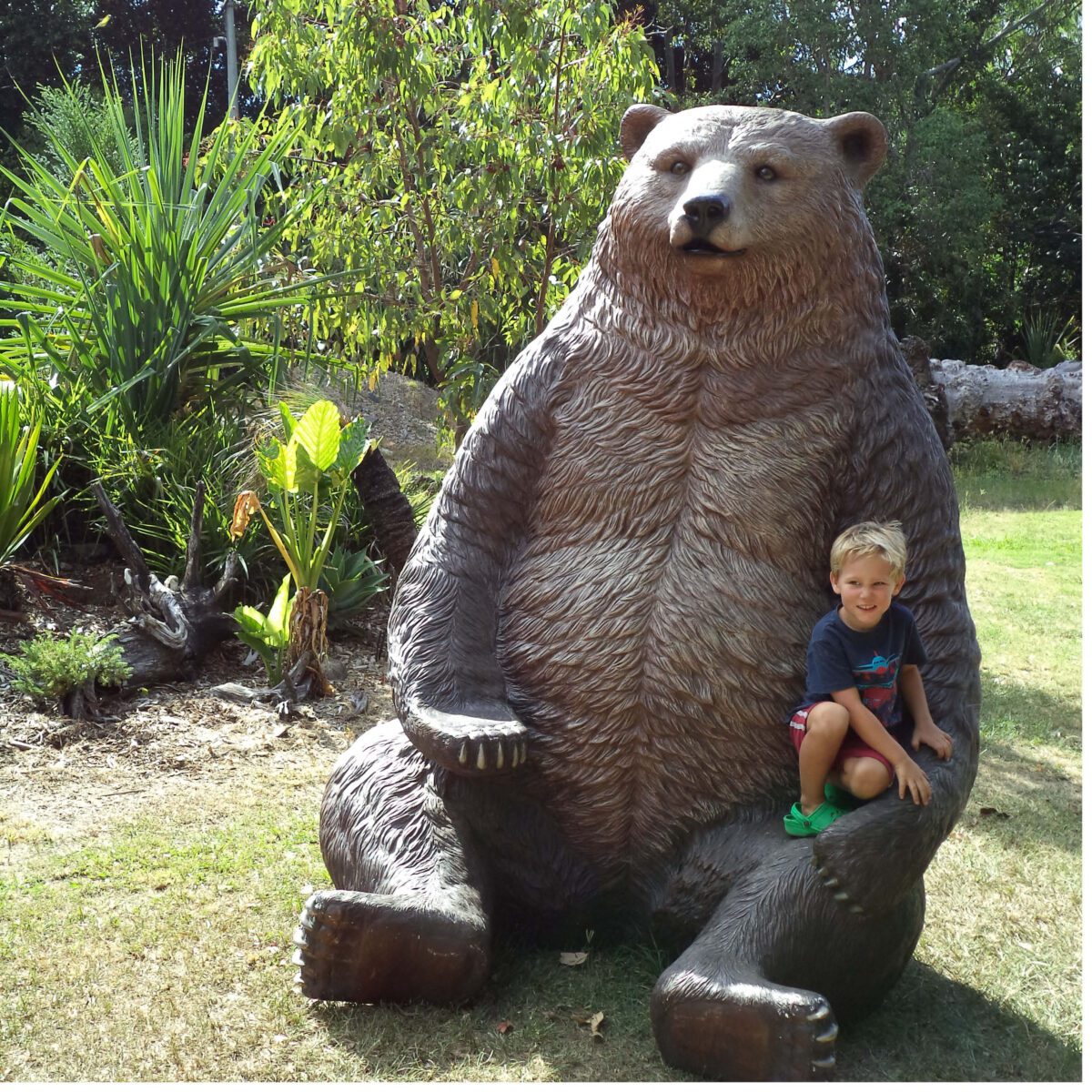 Natureworks Australia Grizzly Bear - Sitting -SKU 130011- shown outside with little boy sitting on lap