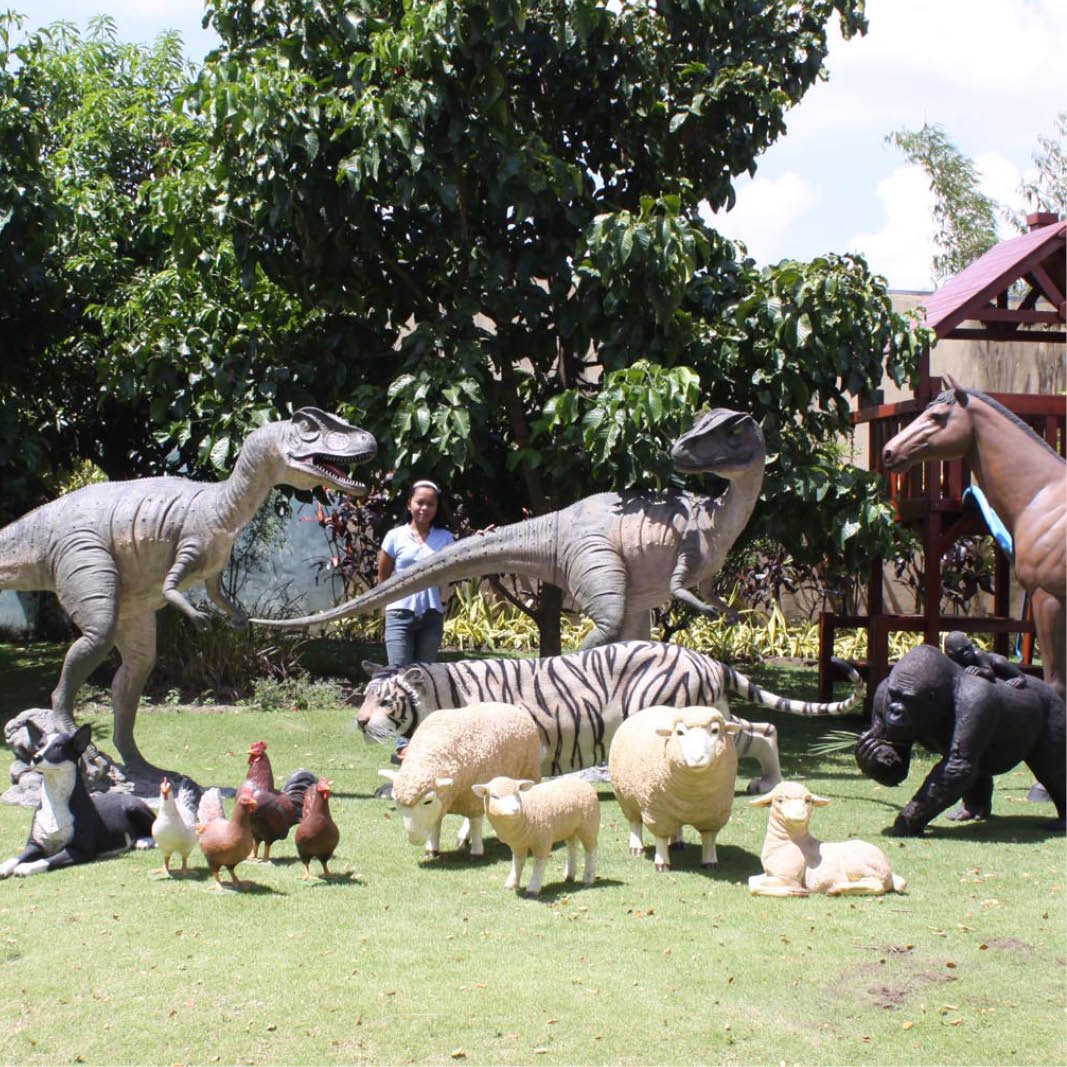 Natureworks Australia Allosaurus dinosaur statue shown outside with other Natureworks products such as sheep, chickens, and horse