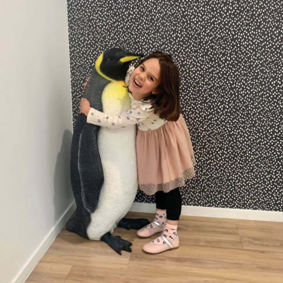 Natureworks Australia Penguin King - 100068 - standing with head up 3ft high - shown with little girl in childcare centre.