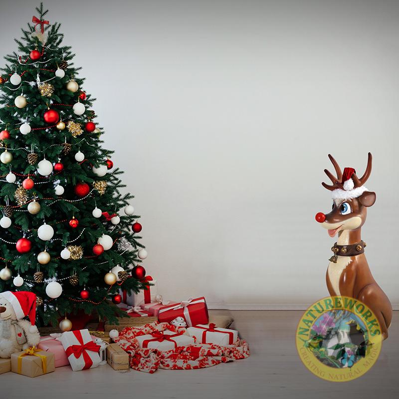Natureworks Australia Funny Reindeer in sitting pose - christmas statue-SKU:080087- shown near a Christmas Tree