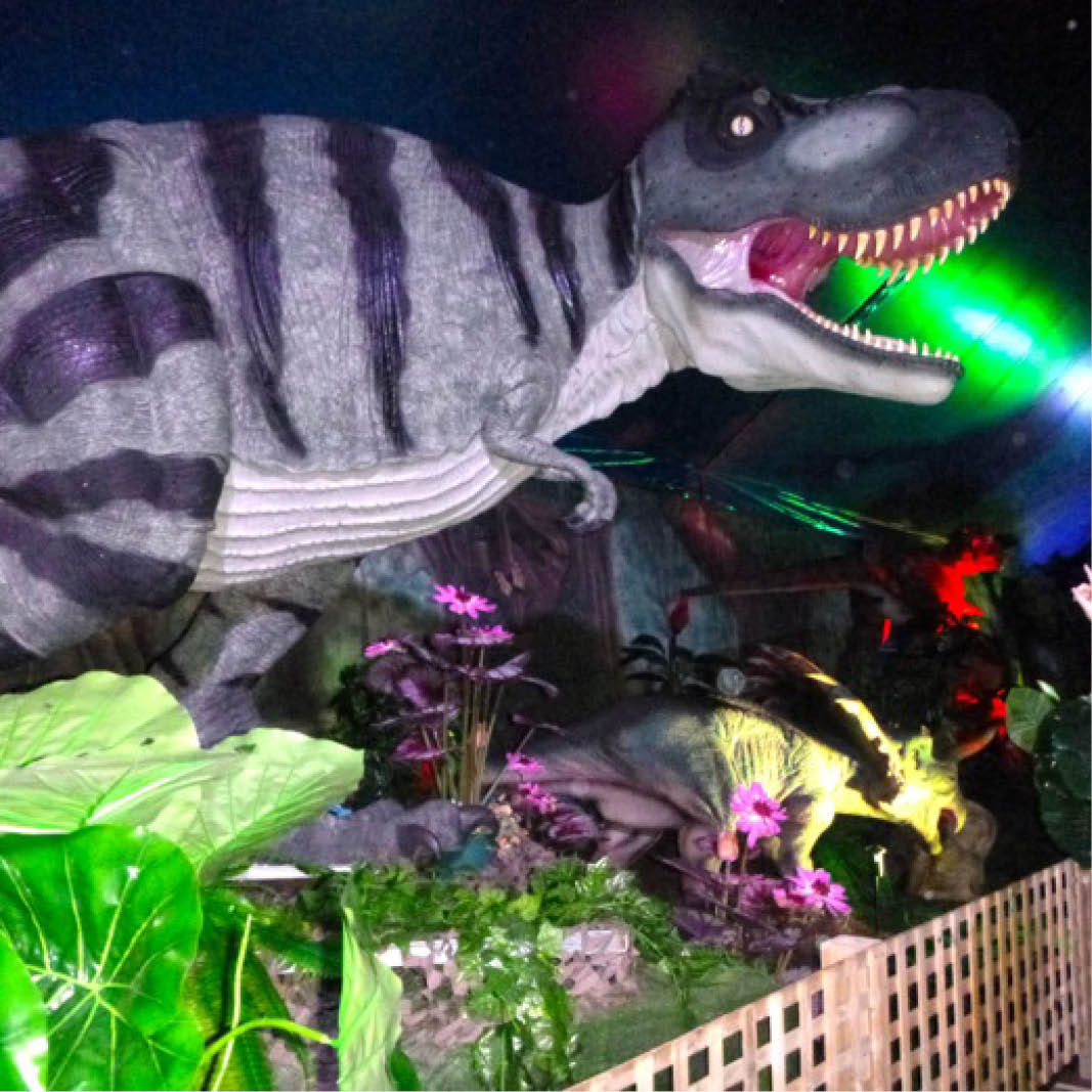 Natureworks Australia Tyrannosaurus Rex - natural painted finish - walking pose- shown in exhibit with lighting and decor- 110073