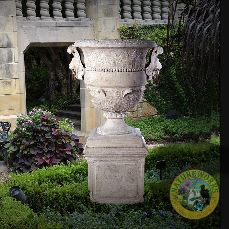 Natureworks Australia Natureworks Large - Urn with lion handles and includes a base plinth - 050701RS - displayed outside in grden