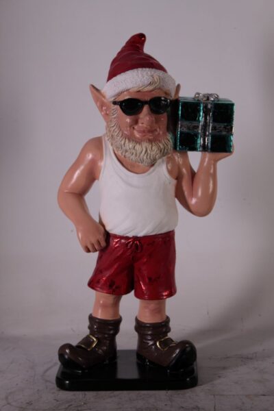 Christmas elf statue wearing Santa hat, sunglasses, red shorts, and holding a gift box.