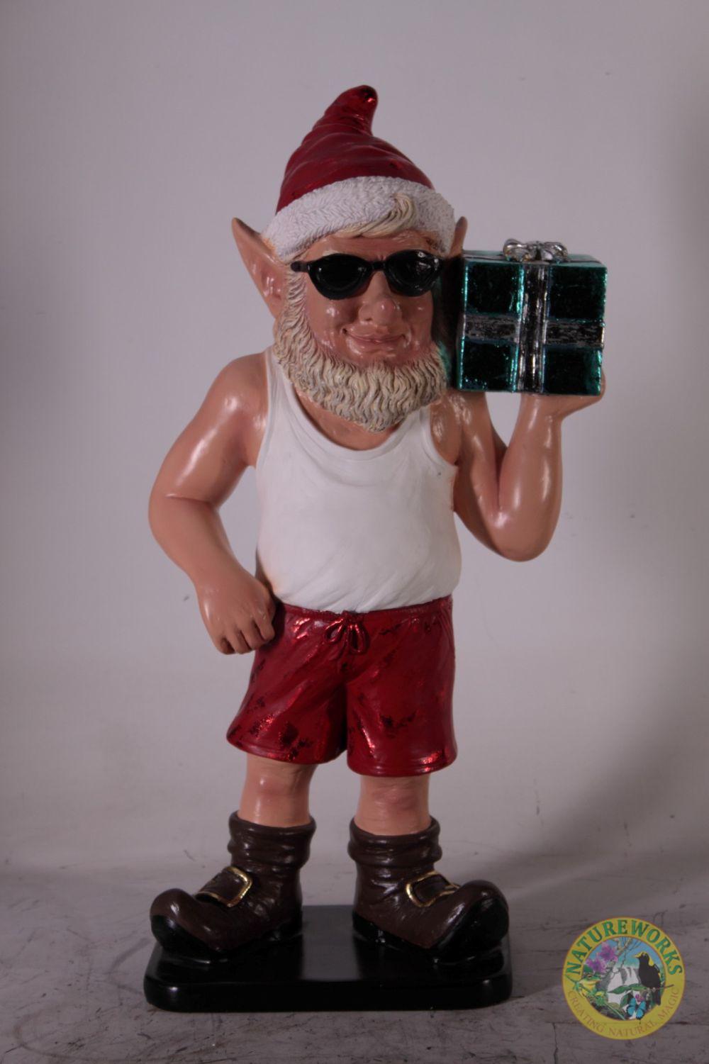 Natureworks Australia Christmas elf statue wearing Santa hat, sunglasses, red shorts, and holding a gift box.