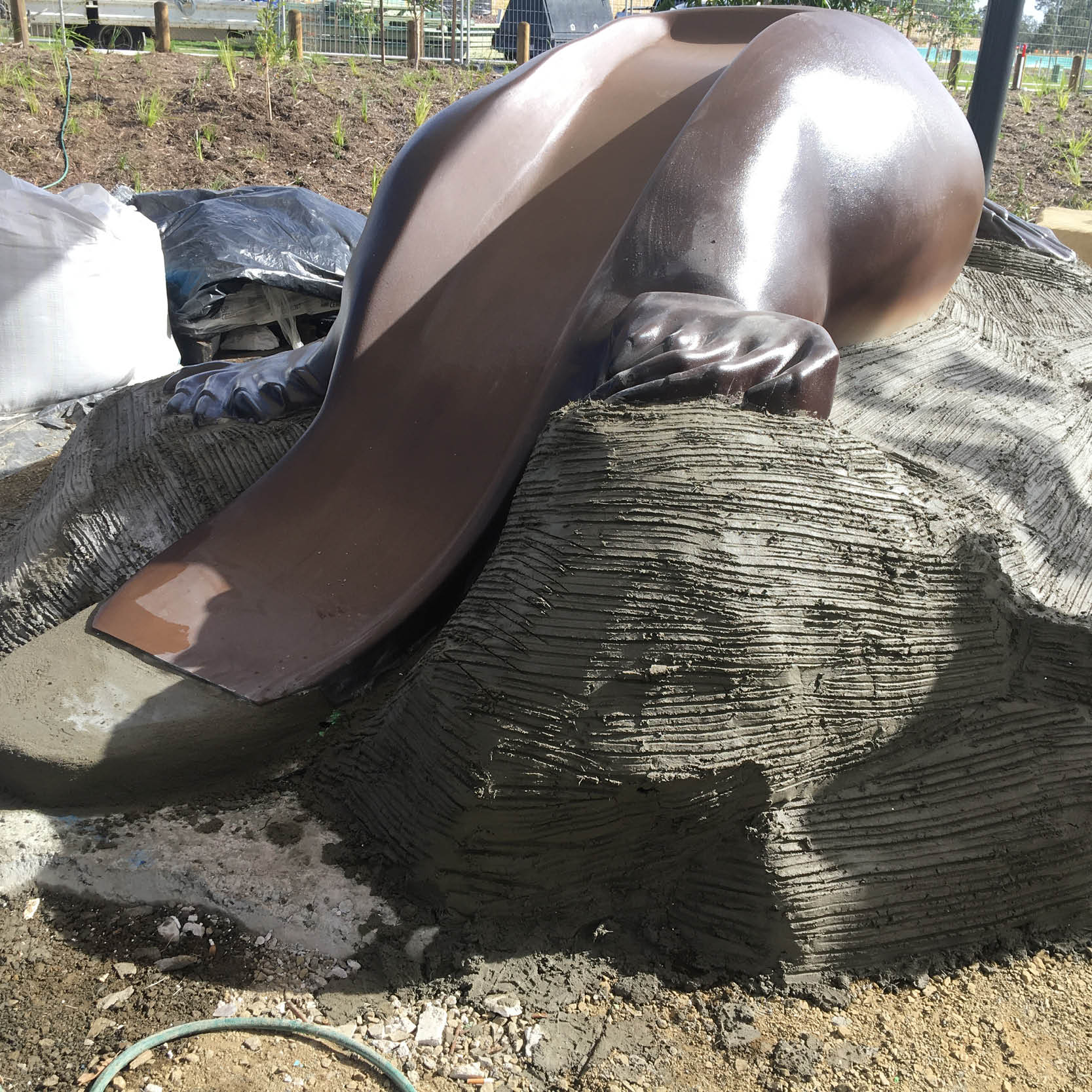 Natureworks Australia Platypus Slide installed in a playground custom sculpt with artificial rock base constructed onsite by Natureworks team. - rear angle view
