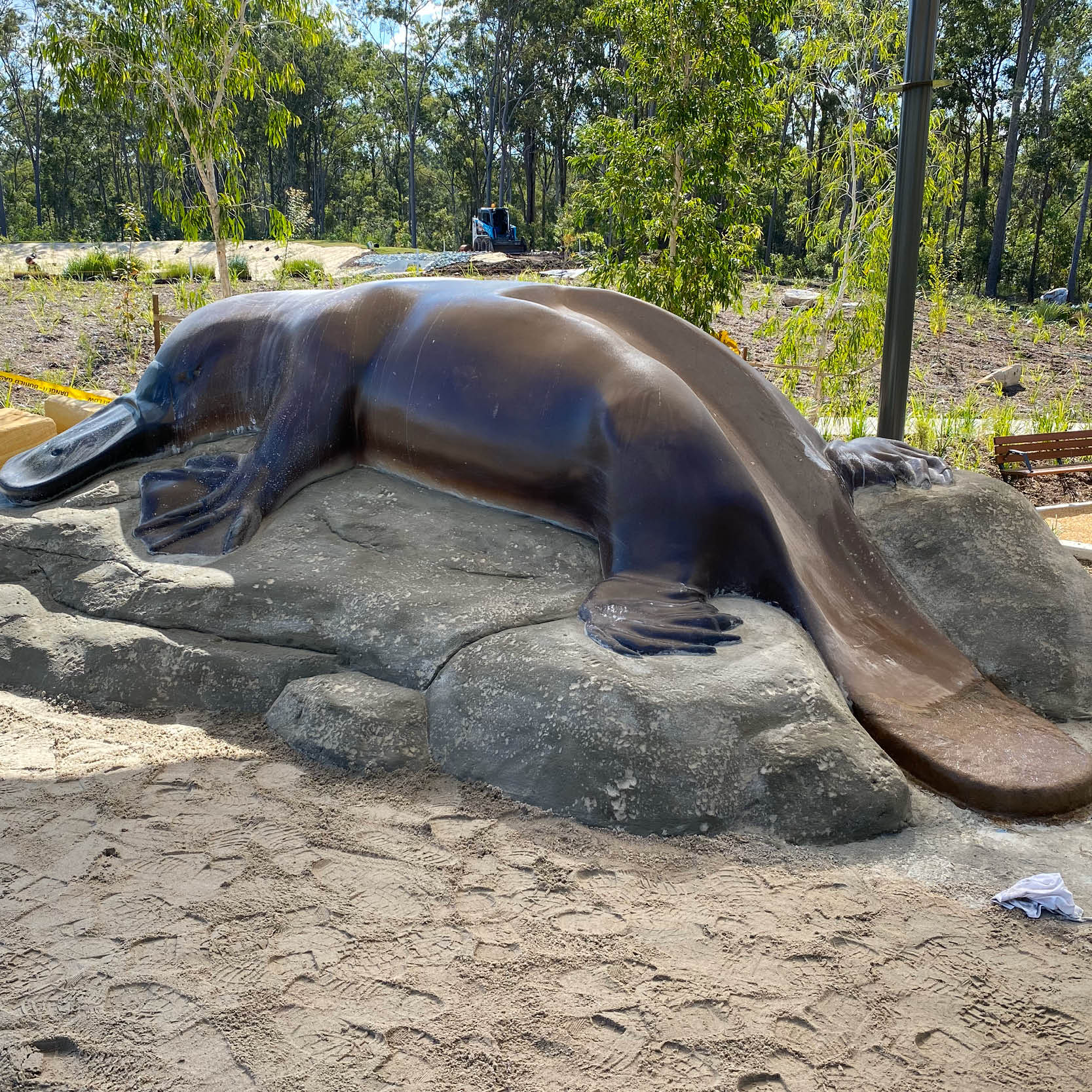 Natureworks Australia Platypus Slide installed in a playground custom sculpt with artificial rock base constructed onsite by Natureworks team. - showing whole slide down the tail