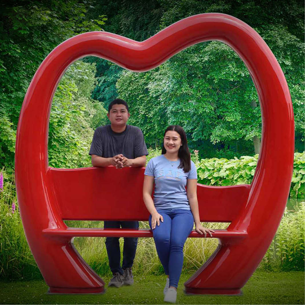 Natureworks Australia Lovers Lounge 240087 - love bench - sturdy construction - bright red colour for weddings and valentines displays- playgrounds, and public parks - shown with couple