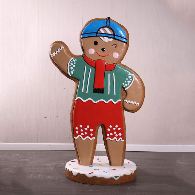 Gingerbread Boy Statue with blue cap, red scarf on iced base
