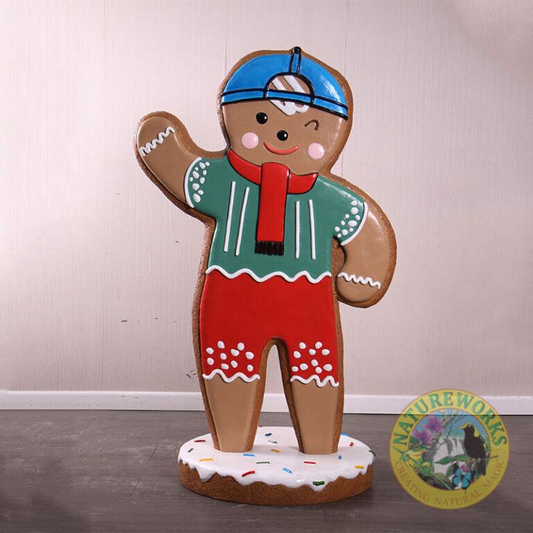 Gingerbread Boy Statue with blue cap, red scarf on iced base