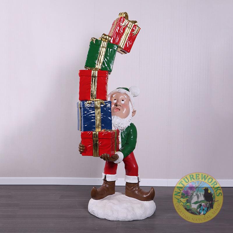 Christmas Elf with Stack of Gifts statue balancing colourful presents on a snow base