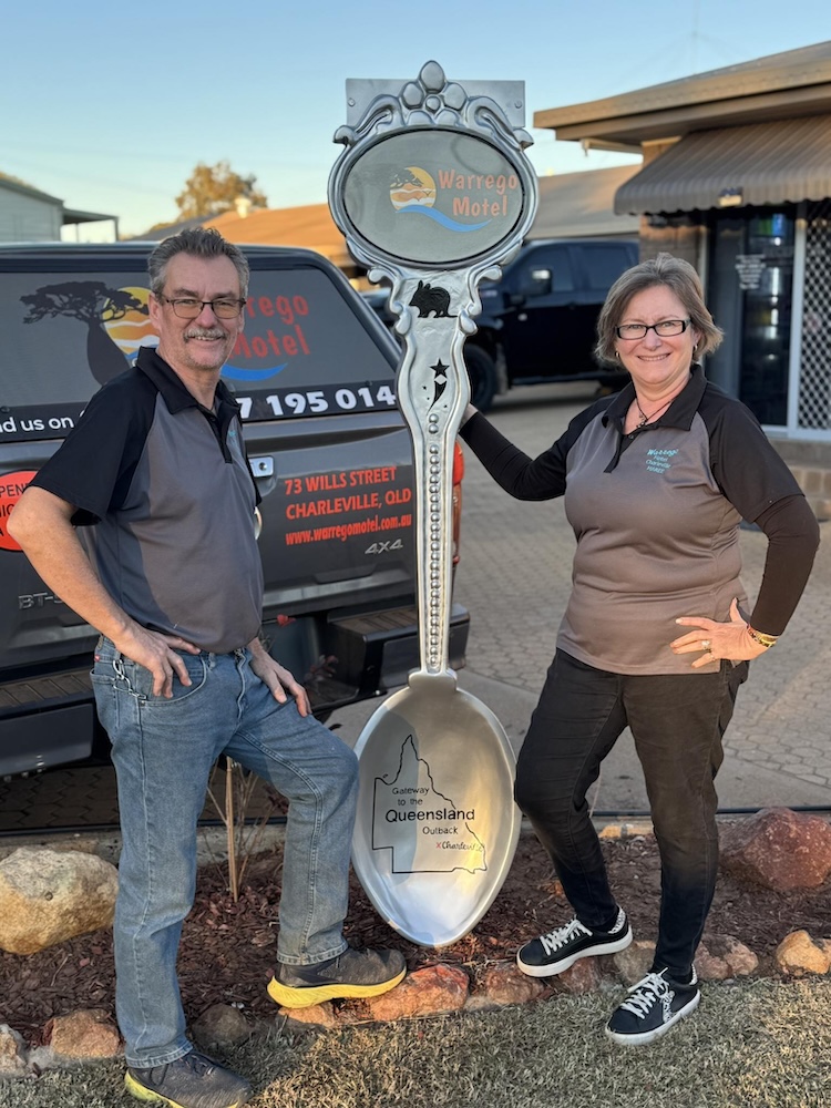 Photo of Guy and Maree with big souvenir spoon sculpture at Warrego Motel Charleville