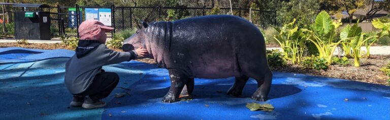 Child with hippo sculpture